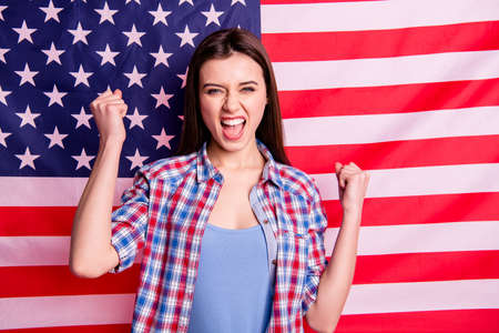 Portrait of cheerful satisfied lady feel rejoice content scream shot yeah have, achievement triumph july holiday vacation tourism wear checkered shirt outfit isolated usa backgroundの写真素材