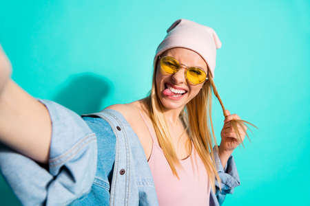 Self-portrait of her she nice-looking attractive lovely charming cute cheerful, cheery crazy girl having fun time isolated on bright vivid shine blue green turquoise backgroundの写真素材