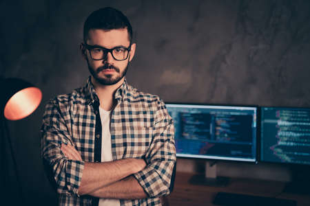 Portrait of confident brunet bearded guy ceo boss chief company founder professional expert specialist behind screen digital cyber security at wooden industrial interior work place stationの写真素材