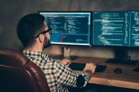 Profile side view of brunet bearded guy ceo boss chief executive designer professional expert specialist sitting in front of screen creating web site at wooden industrial interior work place stationの写真素材