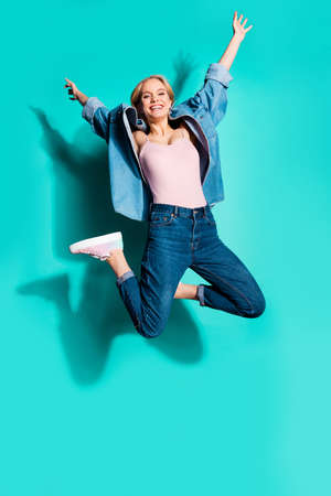 Vertical full length body size profile side view of nice attractive careless carefree cheerful sporty slim fit slender girl having fun isolated on bright vivid shine blue green turquoise backgroundの写真素材