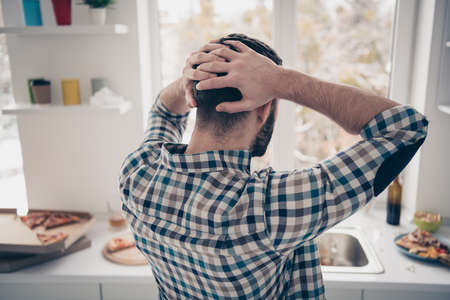 Rear back behind side view portrait of nice attractive tired bored guy looking at chaos mess after...
