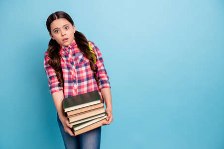 Portrait of nice attractive lovely shocked girl in checked shirt holding in hands many different library science isolated over bright vivid shine blue turquoise backgroundの写真素材
