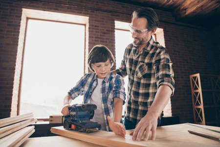 Two nice focused inspired cheerful creative person master builder dad teaching son explaining...
