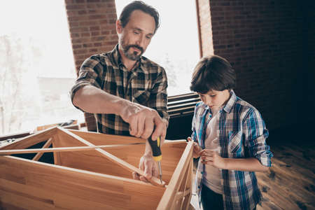Portrait of focused charming nice pretty people person daddy child hold hand tool equipment have work craft craftsmen beard wear checkered shirt clothing interior studioの写真素材