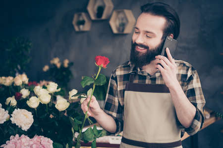 Close up photo handsome trendy charming small business representative stylish hold hand device gadget positive cheerful enjoy rest relax look scent rejoice checked shirt wall greenhouse entrepreneurの写真素材