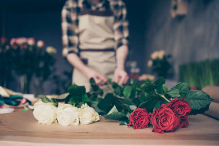 Cropped view blurred photo of concentrated focused guy hold hand touch natural environment assistant salesperson floral environment vendor dressed checkered modern clothes shirt orangeryの写真素材