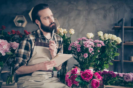 Portrait of focused serious millennial contemplate thoughtful have thoughts choose choice decide decision solution botanical orangery have asters wear checked shirt trendy stylishの写真素材