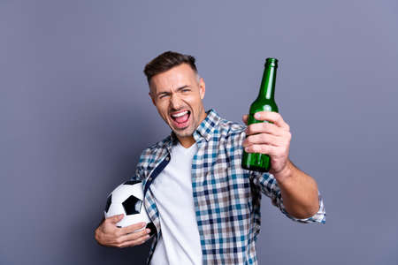 Portrait of his he nice attractive cheerful cheery bearded guy wearing checked shirt holding in hands soccer ball light beer bachelor isolated over gray blue backgroundの写真素材