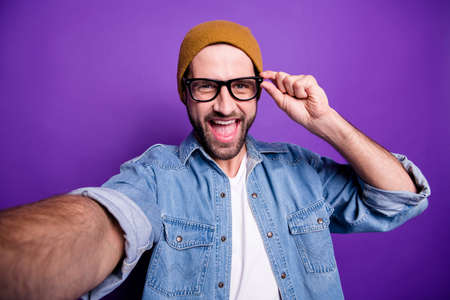 Photo of excited guy online video translation for blog wear specs casual denim outfit isolated violet backgroundの写真素材