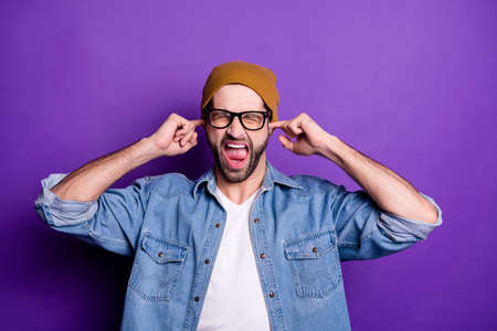 Portrait of his he nice attractive fury aggressive crazy bearded guy closing ears with fingers screaming isolated over bright vivid shine violet lilac backgroundの写真素材