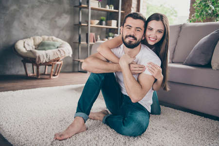 Portrait of his he her she two nice attractive lovely stylish cheerful cheery positive tender people having fun day daydream honeymoon sitting on floor at home house apartment indoorsの写真素材