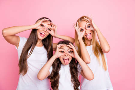 Portrait of three nice attractive lovely glad cheerful cheery girls relatives enjoying holiday weekend free time having fun fooling showing ok-sign isolated over pink pastel backgroundの写真素材