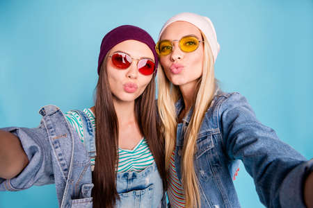 Self-portrait of nice-looking attractive lovely lovable sweet alluring cheerful cheery girls having fun sending you kiss isolated over bright vivid shine blue green turquoise backgroundの写真素材