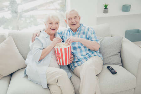 Above high angle view of two nice attractive cheerful cheery positive spouses having fun spending free time watching serial funny cinema in light white interior living-room indoorsの写真素材
