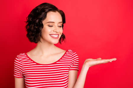 Close-up portrait of her she nice attractive lovely lovable charming cute cheerful cheery content wavy-haired girl holding sale discount ad advert isolated over bright vivid shine red backgroundの写真素材