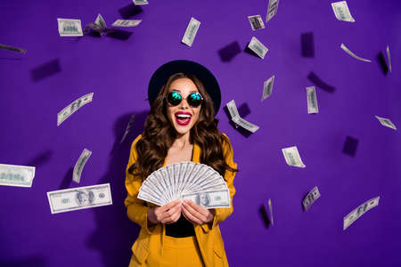 Portrait of her she nice lovely cheerful cheery luxury excited rich wealthy wavy-haired lady winner currency flying budget salary isolated over bright vivid shine violet lilac backgroundの写真素材