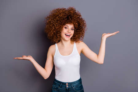 Close up photo of excited curly lady hands hold two products pick select better one wear white...