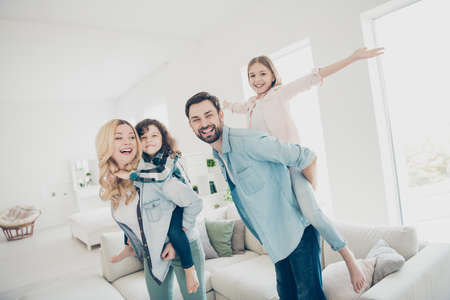 Photo of four family members having best free time pretend funny flight airplane indoors apartmentsの写真素材