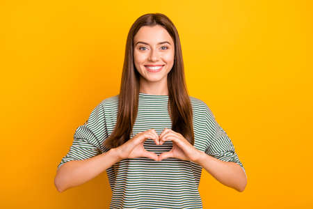 Photo of lovely loving girlfriend showing her cutest side to everyone else while isolated with yellow backgroundの写真素材