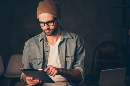 Working at dark time boss guy searching information in e-book wear casual outfit sitting on tableの写真素材