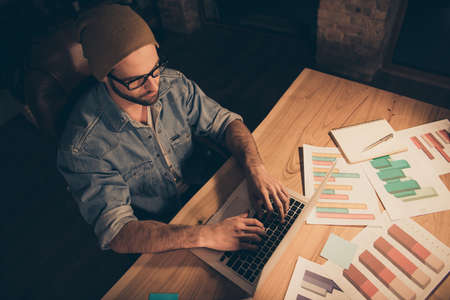Top above and high angle view photo of casual bearded business man having completely deepened into puzzling work focused on strategy about given task in order to finish writing project by morningの写真素材