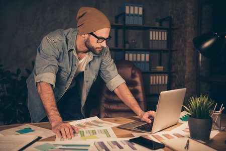 Photo of working at night time boss guy reading contract wear casual outfit stand near table in...