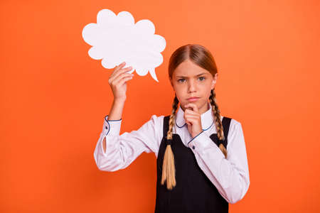 Close-up portrait of her she nice attractive suspicious pre-teen blonde girl holding in hand copy empty blank space card dilemma choose choice isolated on bright vivid shine orange backgroundの写真素材