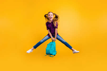 Full length photo of little pupil jump high finally holidays wear casual checkered shirt jeans denim isolated yellow backgroundの写真素材