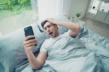 Top above angle photo of impressed horrified student with blonde hair look time scream lying in bed...