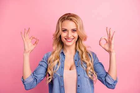 Close-up portrait of her she nice-looking attractive lovely shine content cheerful cheery glad wavy-haired girl showing double ok-sign isolated over pink pastel backgroundの写真素材