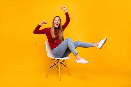 Full body photo of lady sitting chair supporting football team wear pullover isolated yellow backgroundの写真素材