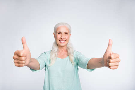 Portrait of cheerful lady showing thumb-up smiling advertising wearing teal pullover isolated over white backgroundの写真素材
