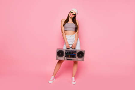 Full body photo of pretty hipster holding boom box smiling wearing eyeglasses eyewear isolated over pink backgroundの写真素材