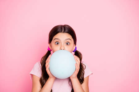 Close up photo of charming kid holding white baloon inflate wearing t-shirt isolated over pink...