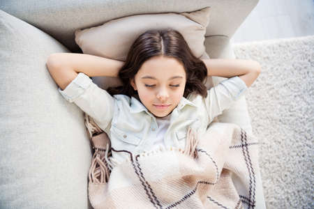 Top above high angle view portrait of her she nice attractive lovely charming cute, calm peaceful dreamy wavy-haired pre-teen girl lying on divan having recreation time indoorsの写真素材