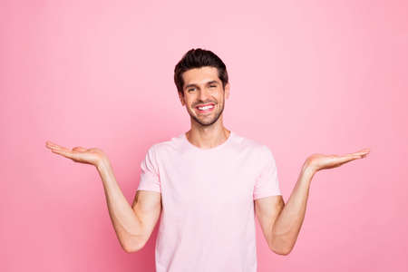 Portrait of his he nice attractive lovely cheerful cheery confident content guy holding copy space promotion good surprise gift present ad advert isolated over pink pastel backgroundの写真素材