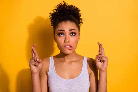Photo of a happy dark skin lady wearing casual jeans denim pants and tank-top isolated bright yellow backgroundの写真素材