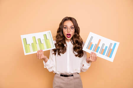 Portrait of her she nice-looking attractive lovely gorgeous professional worried wavy-haired lady holding in hands paper documents marketing isolated over beige pastel backgroundの写真素材