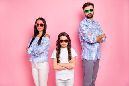 Portrait of smart people with wavy curly brunet hair crossing their hands looking wearing eyeglasses eyewear plaid shirt t-shirt isolated over pink backgroundの写真素材