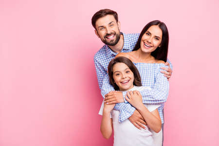 Portrait of funny family laughing wearing plaid shirts off-shoulders white t-shirt isolated over pink backgroundの写真素材