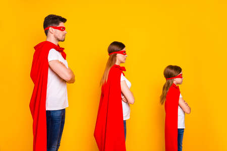 Family spending leisure time playing cartoon characters wear superhero costume isolated yellow backgroundの写真素材