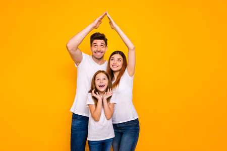 Daddy mommy and little foxy lady under protection on arms roof wear casual outfit isolated yellow backgroundの写真素材