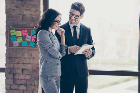 Photo of couple of cheerful coworkers watching their income rising after crisis period in companyの写真素材