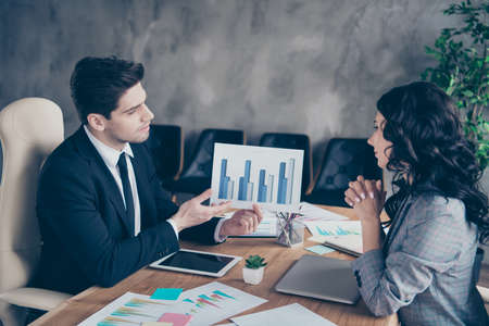 Photo of two business people lady and guy discussing earnings plan sitting office chairs workshopの写真素材