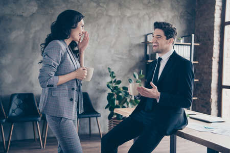Photo of two business people having coffee break standing workstation communicating dressed formal wear suitsの写真素材