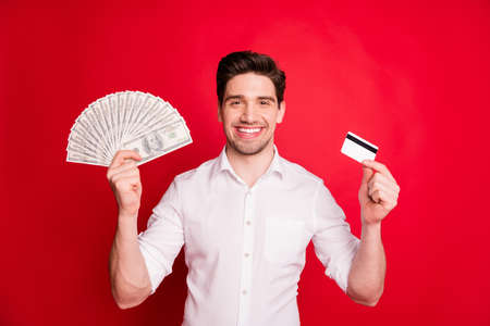Photo of wealthy successful man, enjoying having received salary fun while isolated with red backgroundの写真素材