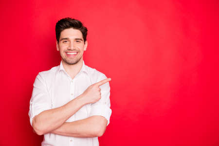 Portrait of his he nice attractive cheerful cheery content guy employee employer, pointing forefinger aside ad sale discount black Friday isolated over bright vivid shine red backgroundの写真素材
