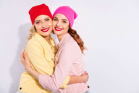 Photo of two pretty ladies holding each other close in hands wear casual clothes isolated white backgroundの写真素材