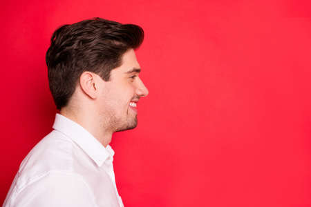 Close-up profile side view portrait of his he nice attractive cheerful cheery guy student copy empty blank space advert ad isolated over bright vivid shine red backgroundの写真素材